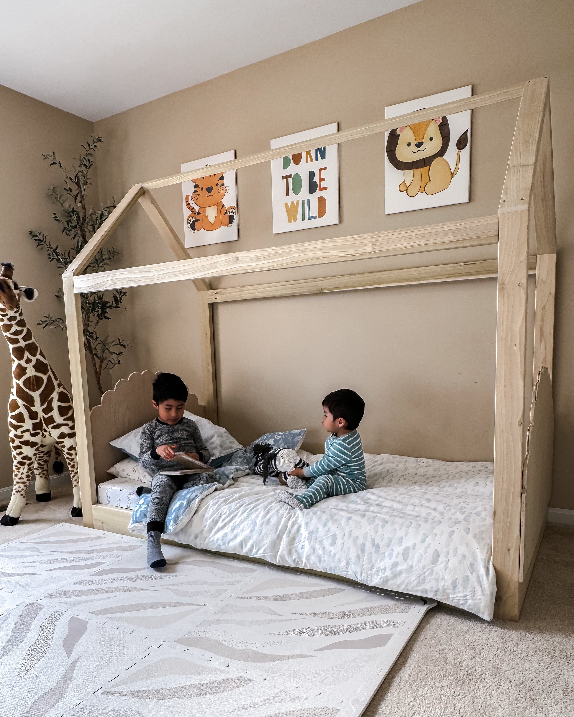 A cozy house-shaped children's bed made entirely of natural wood, featuring a headboard and footboard for added comfort and style. The bed resembles a quaint cottage. Crafted from sturdy wood, the frame provides stability and durability. Inside, a comfortable mattress with soft bedding invites children to rest and play. This wooden house bed with a headboard and footboard creates a cozy and inviting sleep space, perfect for fostering imagination and comfort in a child's bedroom.