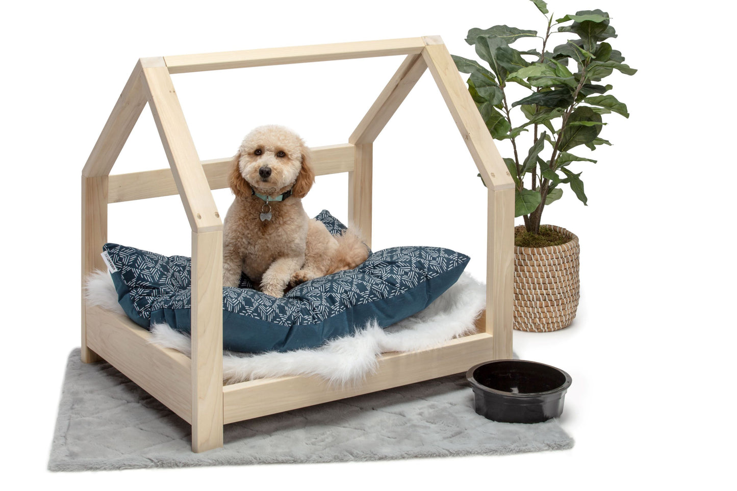A miniature pet bed crafted entirely from smooth wood, designed for small animals such as cats or small dogs. The bed features a simple yet elegant frame, with rounded corners for comfort and safety. Inside, a soft cushion provides a cozy spot for pets to rest and relax. Placed in a cozy corner of the room with a small blanket nearby, this wooden pet bed offers a stylish and comfortable retreat for furry companions to curl up in.