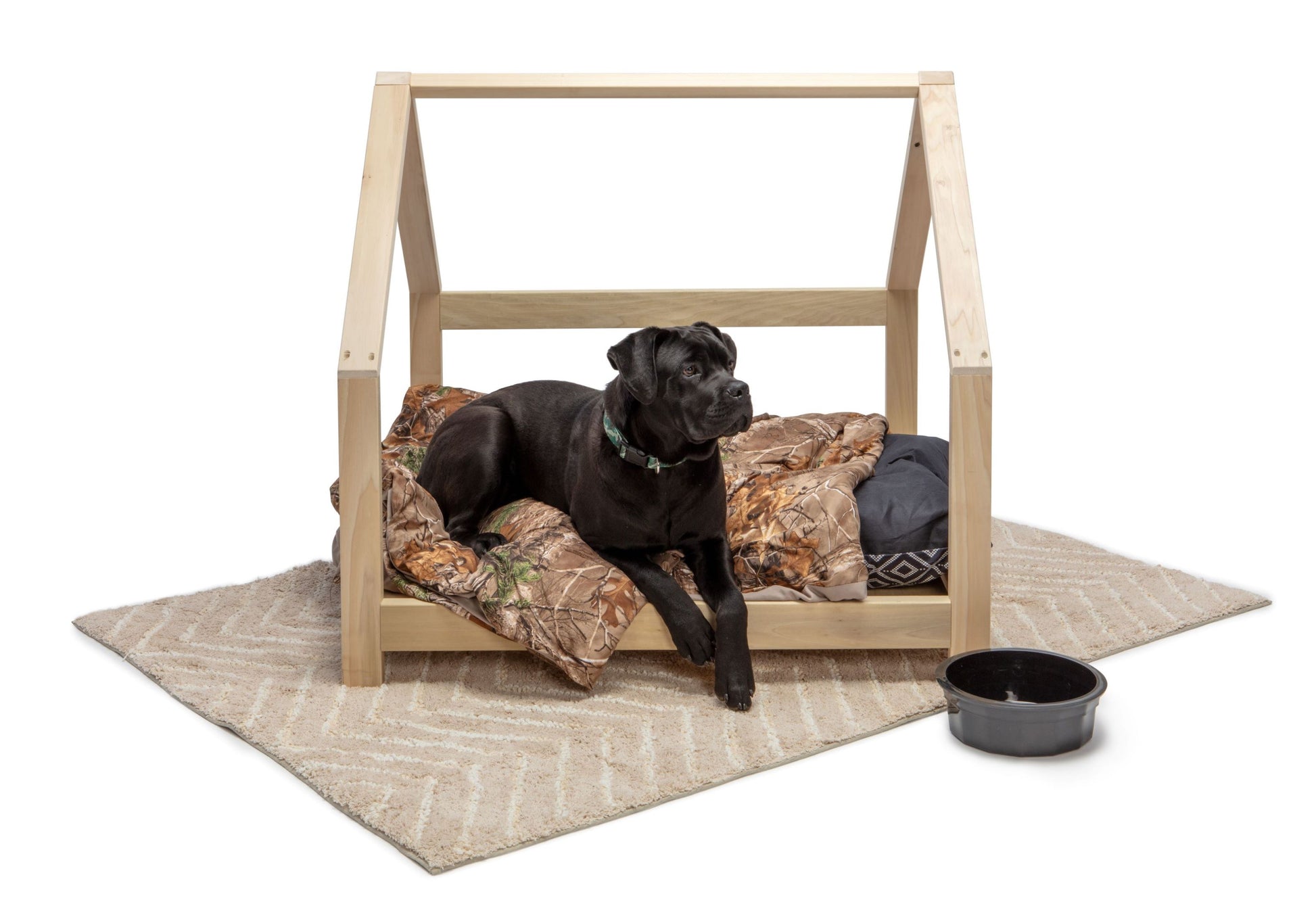 A large pet bed crafted entirely from smooth wood, designed for small animals such as cats or small dogs. The bed features a simple yet elegant frame, with rounded corners for comfort and safety. Inside, a soft cushion provides a cozy spot for pets to rest and relax. Placed in a cozy corner of the room with a small blanket nearby, this wooden pet bed offers a stylish and comfortable retreat for furry companions to curl up in.