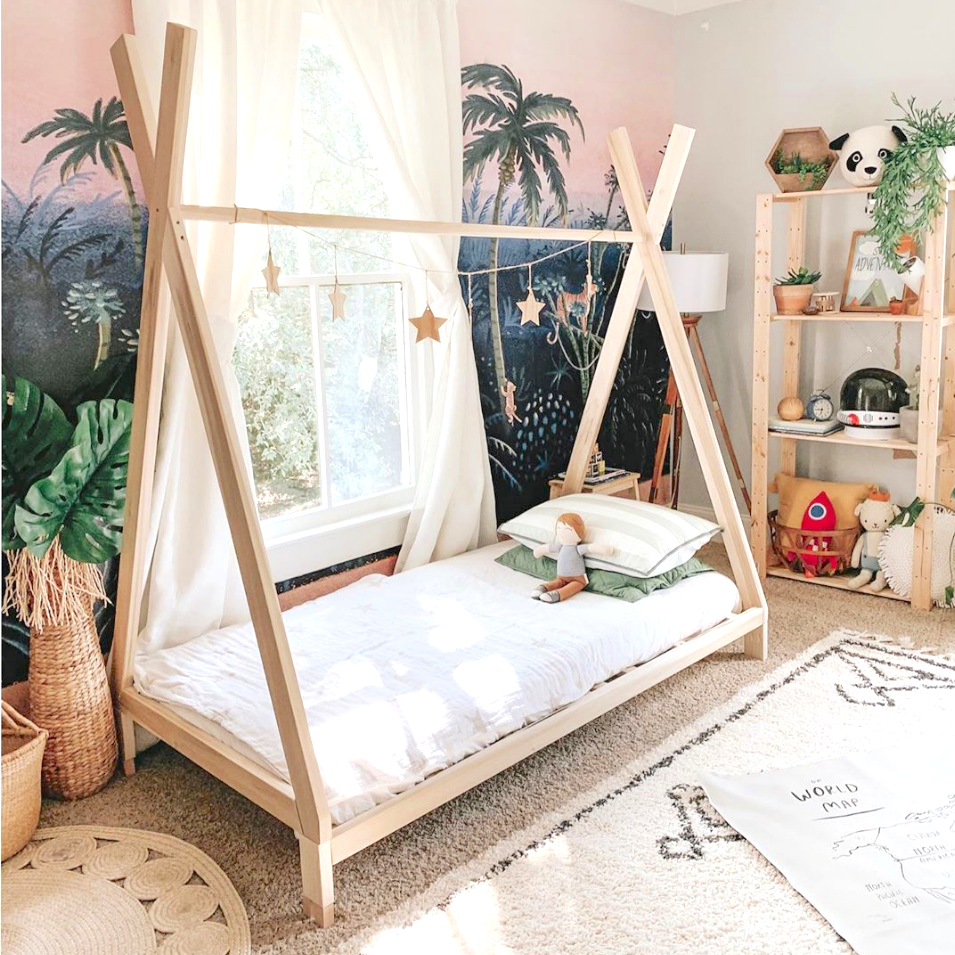 A charming toddler teepee bed crafted entirely from sturdy wood, resembling a miniature teepee structure. The bed's frame features natural wood tones with smooth, rounded edges for safety. Inside the teepee, a soft mattress with cozy bedding beckons, while the open design allows for imaginative play and a sense of adventure. Placed in a room adorned with playful decorations, this bed invites young ones to embark on a whimsical journey of sleep and play.