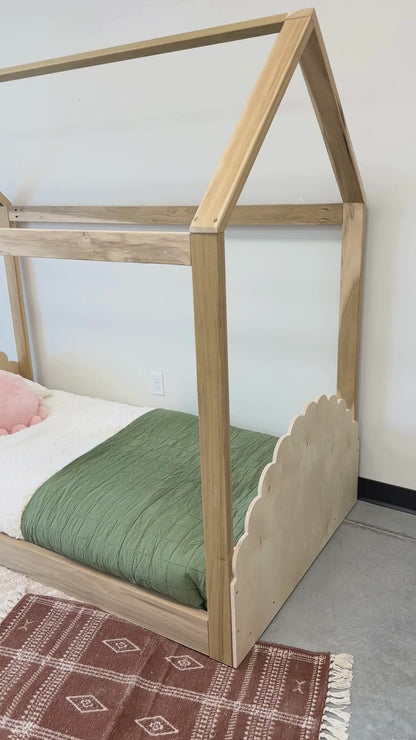 A cozy house-shaped children's bed made entirely of natural wood, featuring a headboard and footboard for added comfort and style. The bed resembles a quaint cottage. Crafted from sturdy wood, the frame provides stability and durability. Inside, a comfortable mattress with soft bedding invites children to rest and play. This wooden house bed with a headboard and footboard creates a cozy and inviting sleep space, perfect for fostering imagination and comfort in a child's bedroom.