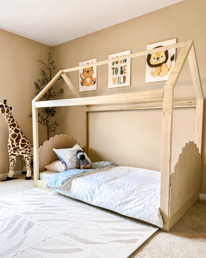 A cozy house-shaped children's bed made entirely of natural wood, featuring a headboard and footboard for added comfort and style. The bed resembles a quaint cottage. Crafted from sturdy wood, the frame provides stability and durability. Inside, a comfortable mattress with soft bedding invites children to rest and play. This wooden house bed with a headboard and footboard creates a cozy and inviting sleep space, perfect for fostering imagination and comfort in a child's bedroom.