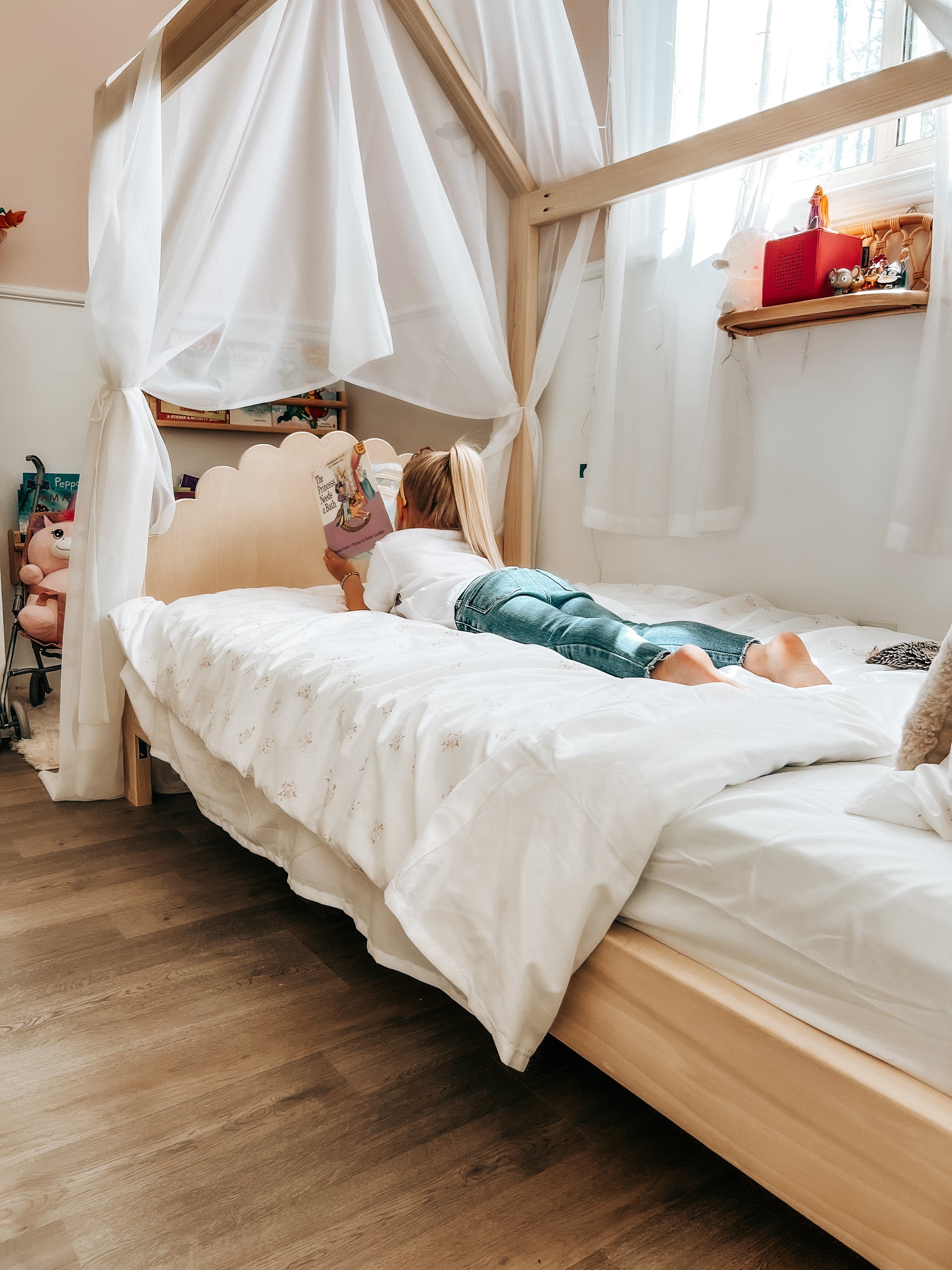 A cozy house-shaped children's bed made entirely of natural wood, featuring a headboard and footboard for added comfort and style. The bed resembles a quaint cottage. Crafted from sturdy wood, the frame provides stability and durability. Inside, a comfortable mattress with soft bedding invites children to rest and play. This wooden house bed with a headboard and footboard creates a cozy and inviting sleep space, perfect for fostering imagination and comfort in a child's bedroom.