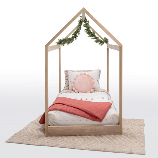A charming house-shaped children's bed crafted entirely from natural wood, featuring a cozy and inviting design. The bed resembles a miniature house, complete with a peaked roof, window cutouts, and a sturdy wooden frame. Inside, a comfortable mattress is adorned with soft bedding, providing a cozy spot for children to sleep and play. With safety rails along the sides for added security, this wooden house bed creates a whimsical and imaginative sleep space for young ones to enjoy in their bedroom.